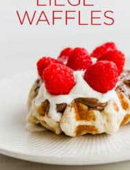 Belgian liege waffle topped with Nutella, whipped cream, and raspberries.