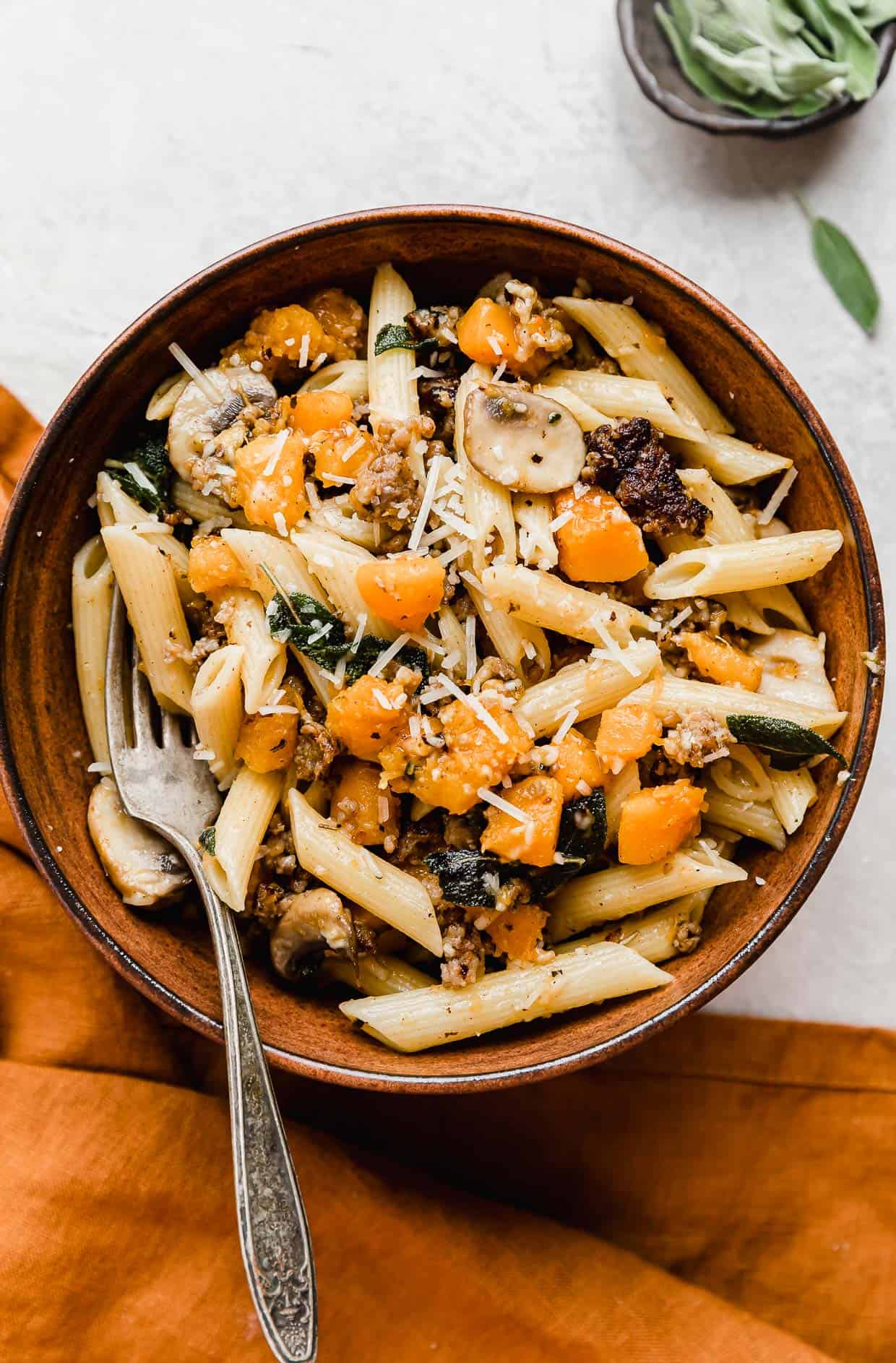 A brown bowl with Butternut Squash Mushroom Pasta in it.