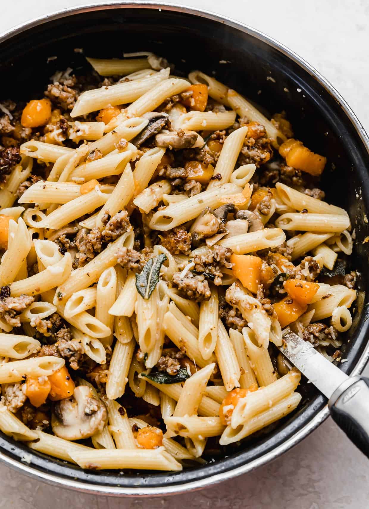 Butternut Squash Mushroom Pasta with sage, in a large black pot.