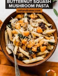 Butternut Squash Mushroom Pasta with brown butter sage in a brown bowl on a white background.