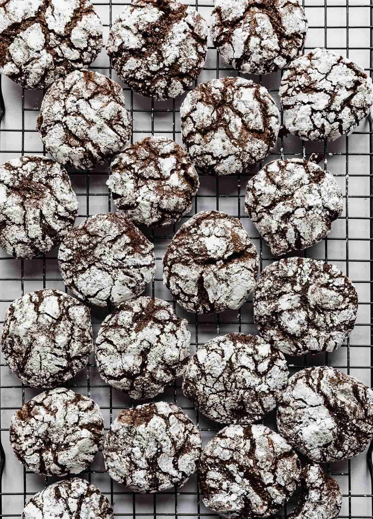 Chocolate Crinkle Cookies on a black wire cooling rack.