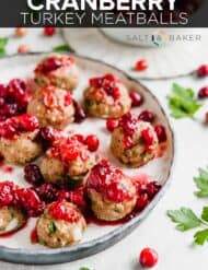Baked turkey meatballs topped with cranberry sauce with the words, "Cranberry Turkey Meatballs" written in white text over the photo.