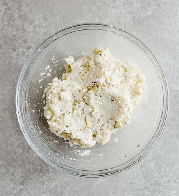 A bowl of herbed ricotta for a lasagna soup recipe.