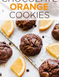 Double chocolate orange cookies surrounded by fresh orange wedges and mini chocolate chips.