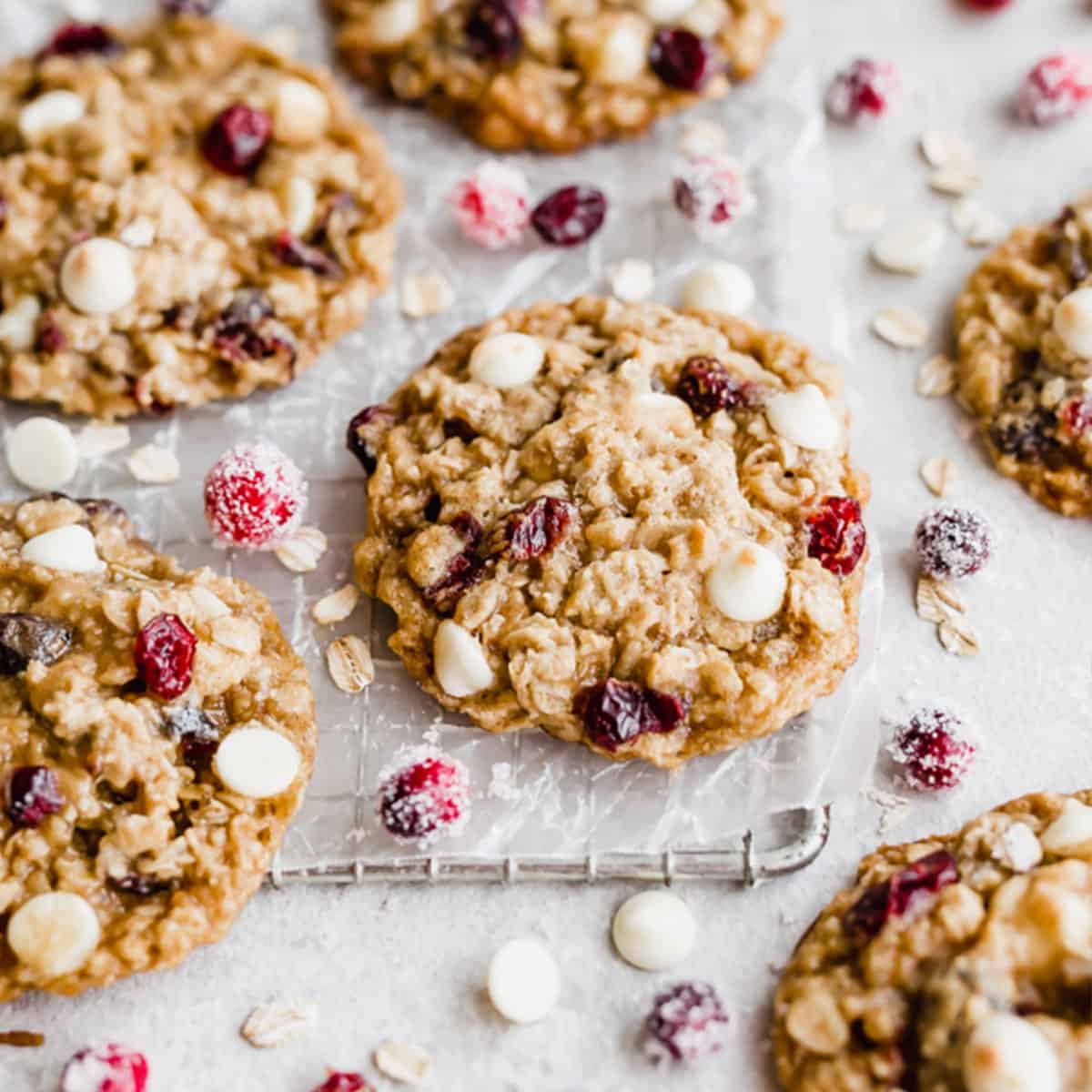 A White Chocolate Cranberry Oatmeal Cookie on a small wire rack that's on a white background.
