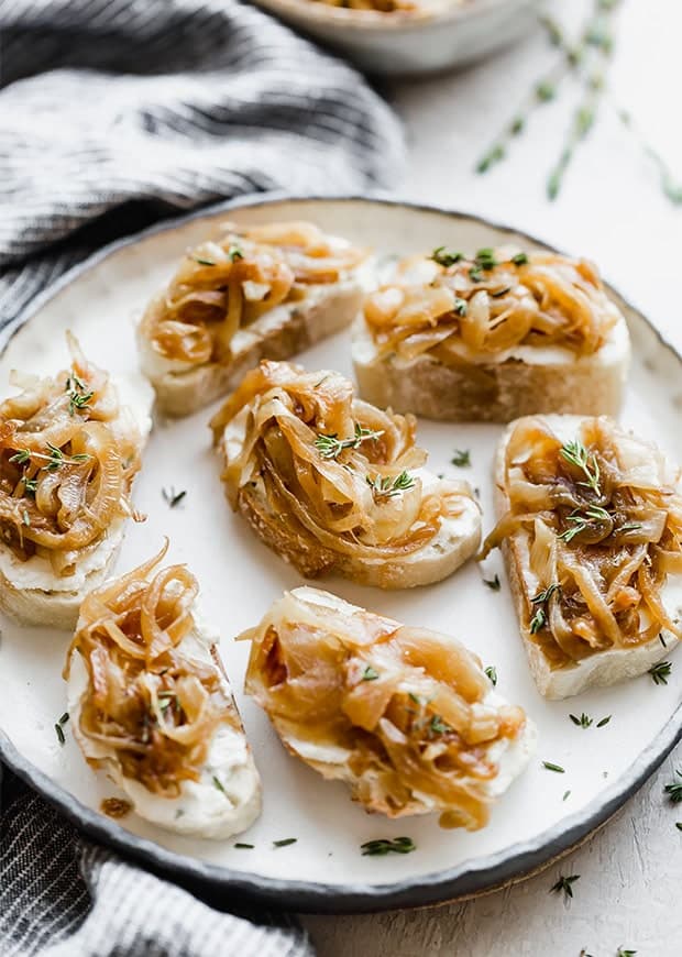 A plate with caramelized onion topped goat cheese crostini.