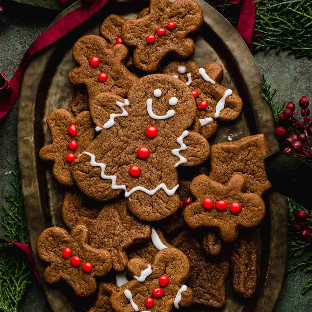 A cute gingerbread man cookie decorated with red frosting buttons and white eyes and smile.