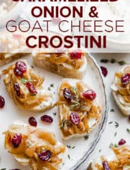 Crostini topped with goat cheese and caramelized onions with a garnish of fresh thyme and dried cranberries.