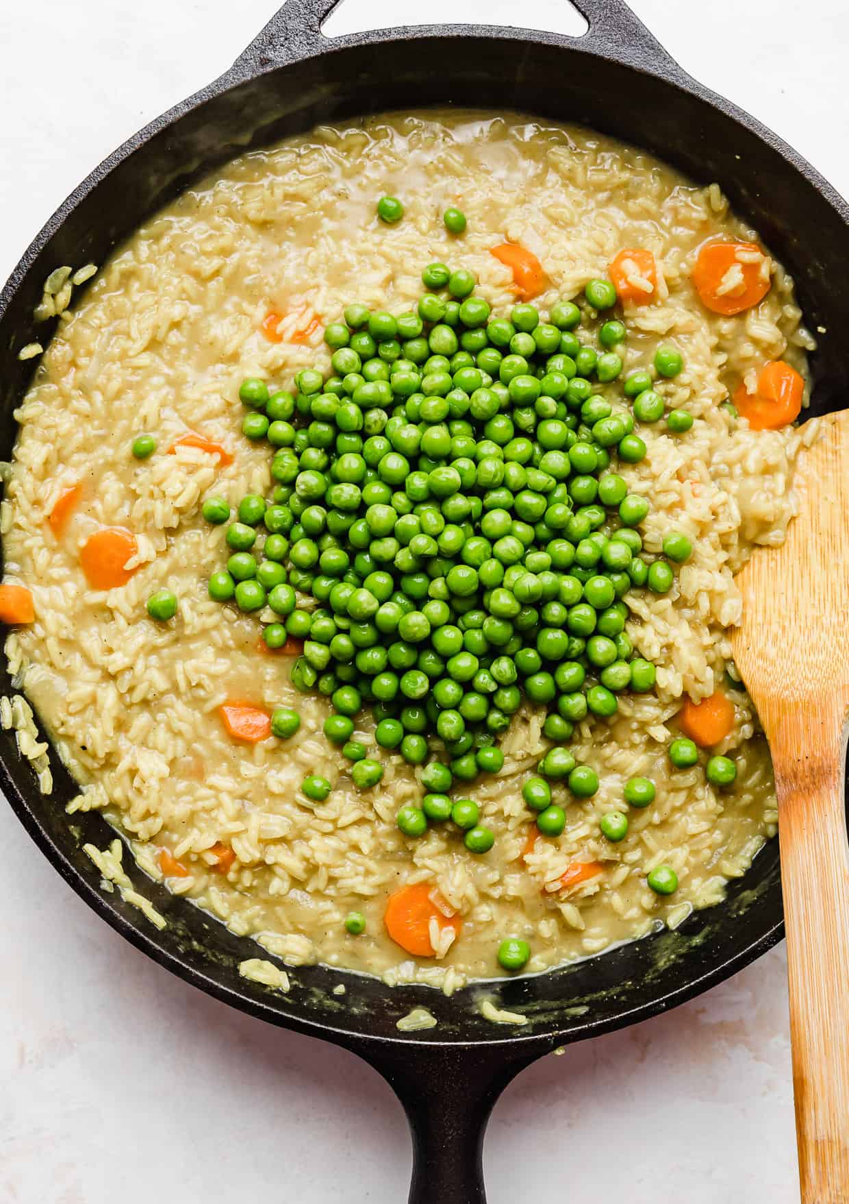 Peas in a skillet filled with Curry Chicken Rice and Peas recipe.