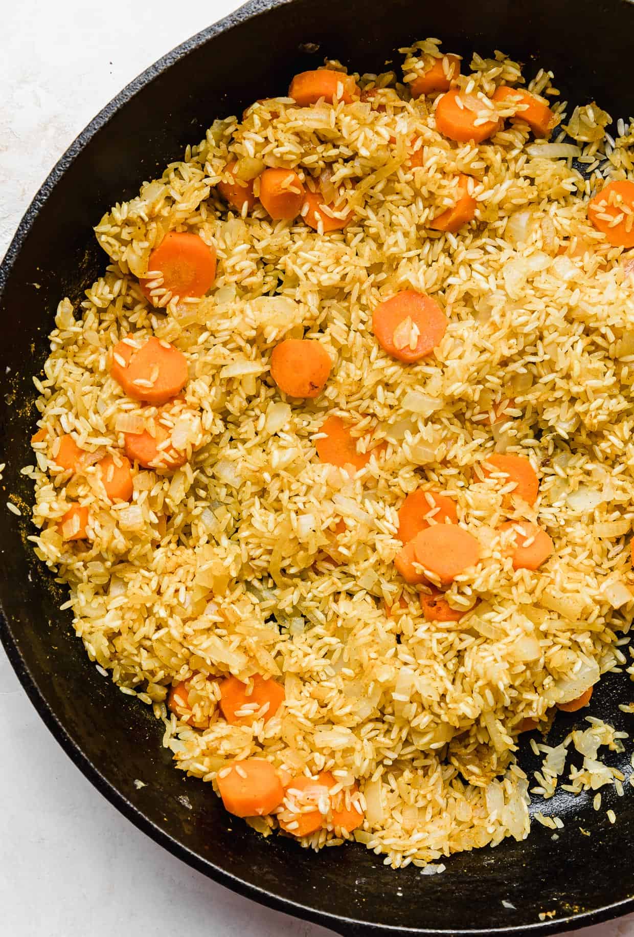 Carrots and rice in a black skillet.