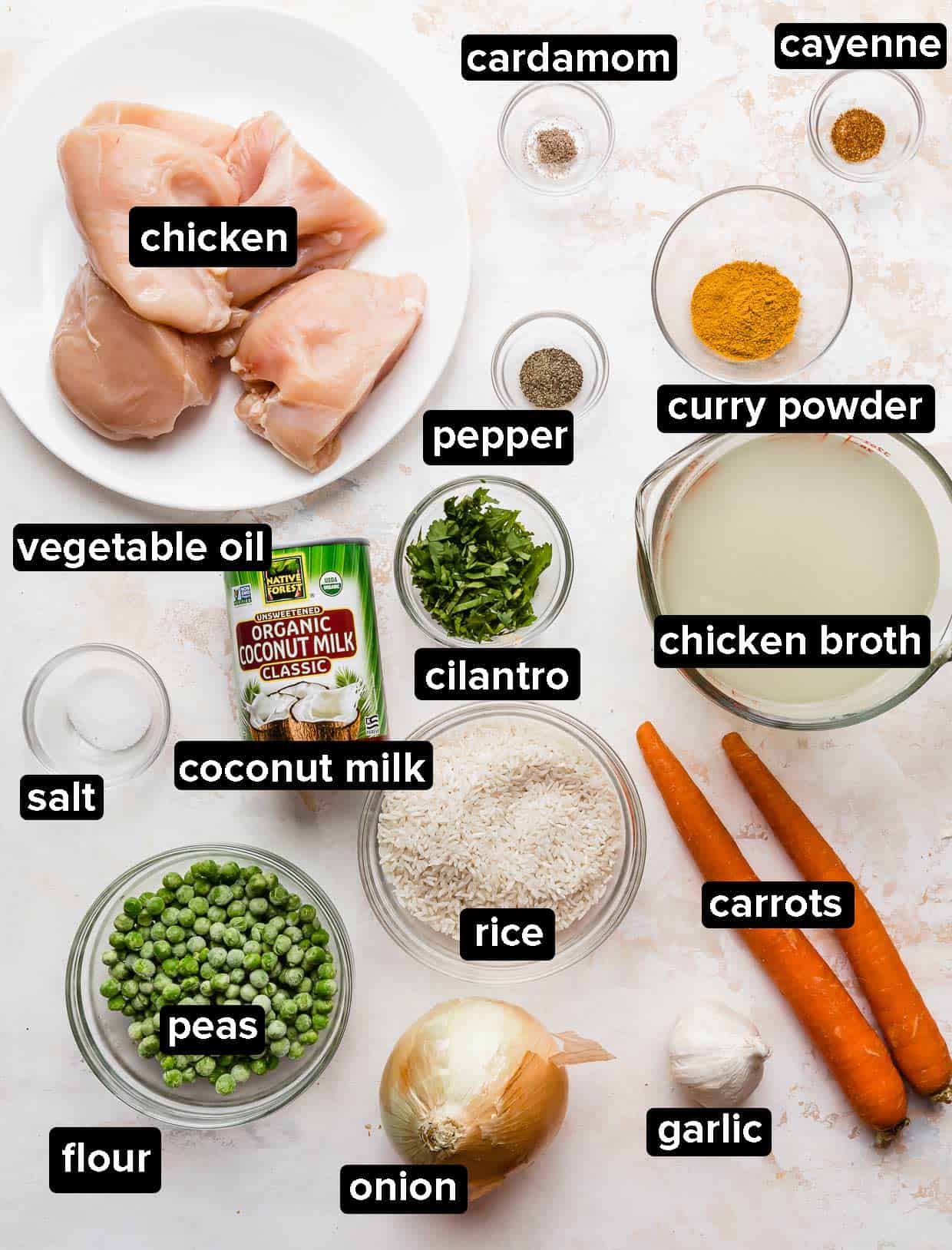 Ingredients for Curry Chicken Rice and Peas and carrots on a white textured background.