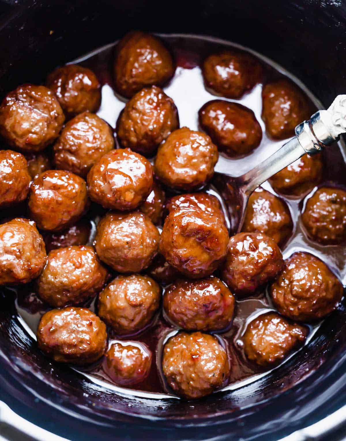 Grape Jelly Meatballs in a round black crock pot.