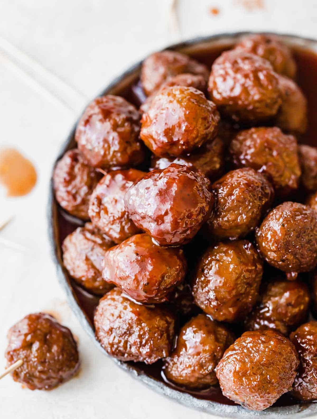 Overhead photo of Grape Jelly Meatballs on a plate against a white background.