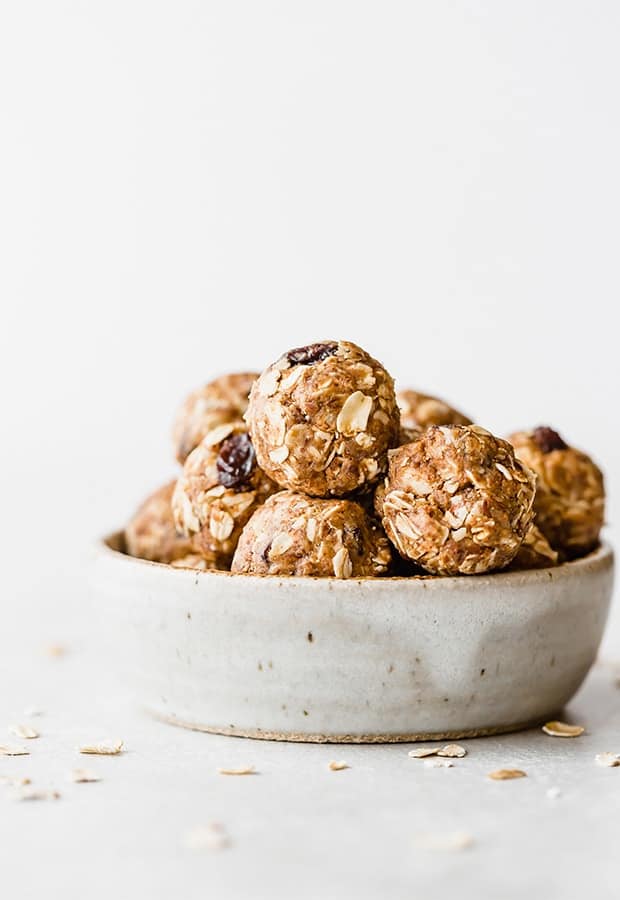 Oatmeal raisin energy bites stacked inside a small ceramic bowl.