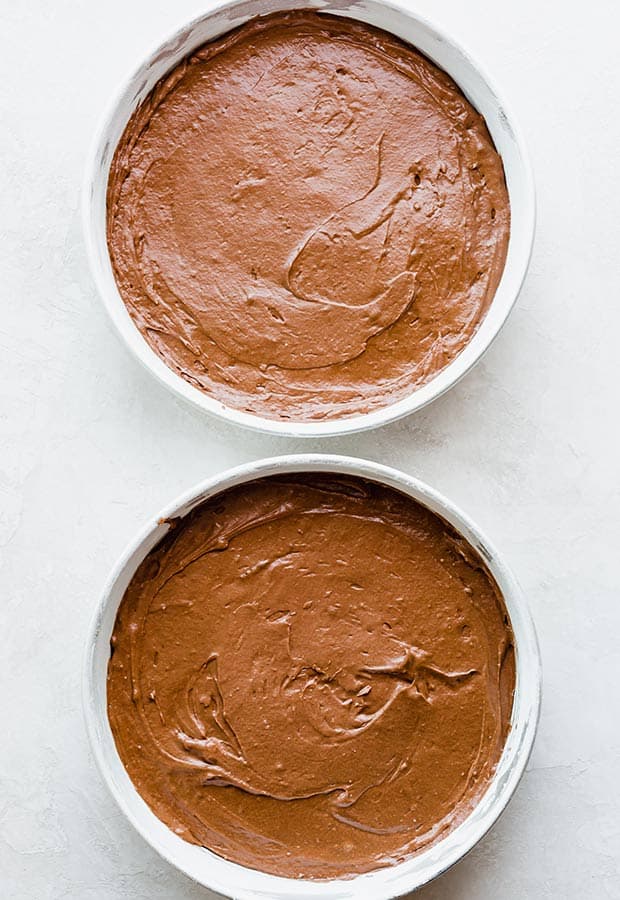 Overhead photo of two circular cake pans filled with German chocolate cake batter.