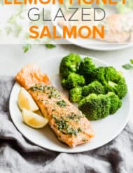 A cooked fillet of salmon topped with a lemon honey glaze, with a serving of broccoli alongside the salmon.