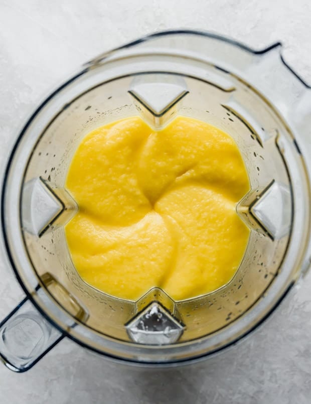 A blender full of freshly blended mango puree.