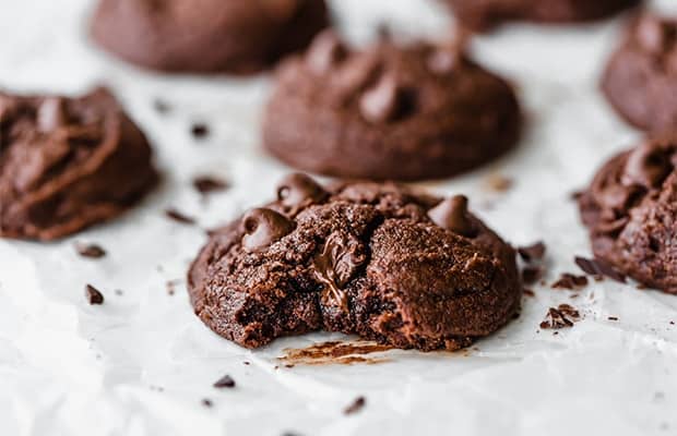 A brownie cookie with a bite taken out of it, showcasing the melty chocolate chips.