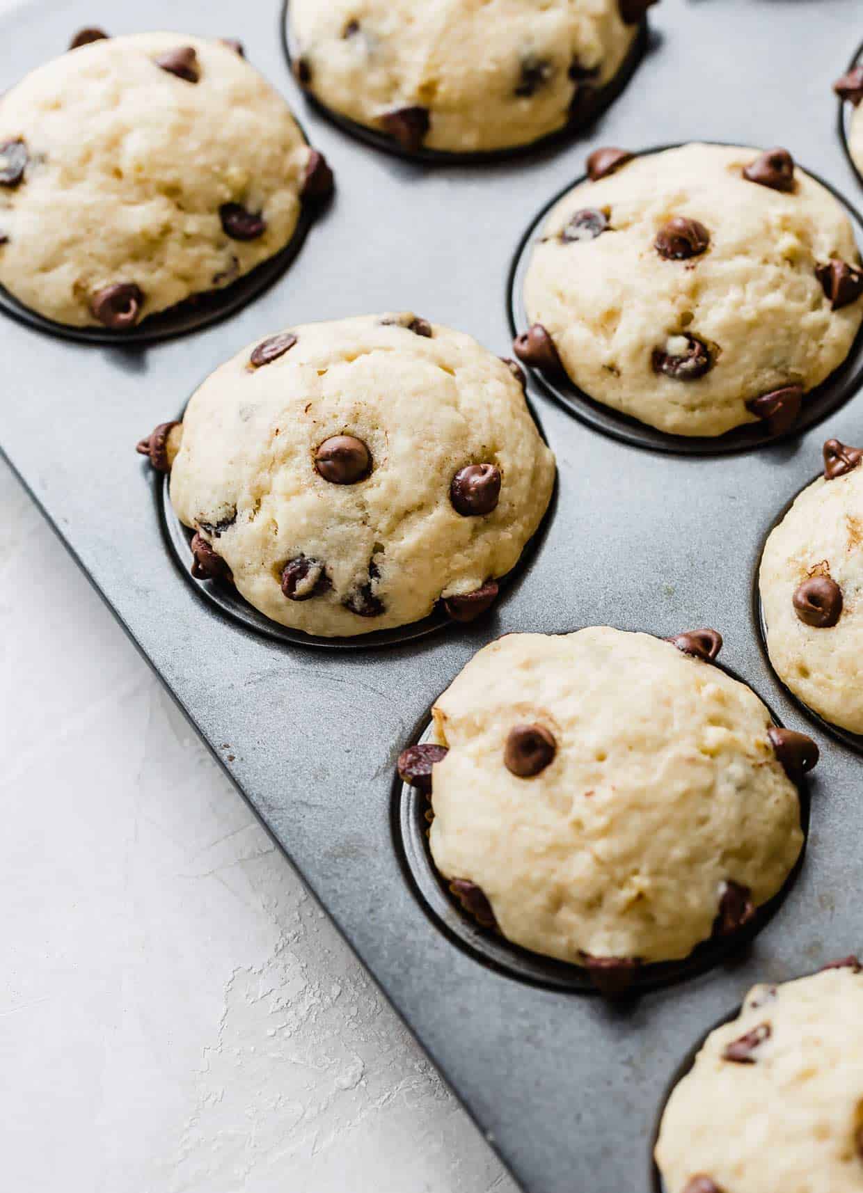 Baked banana chocolate chip muffins with buttermilk, in a muffin tin.