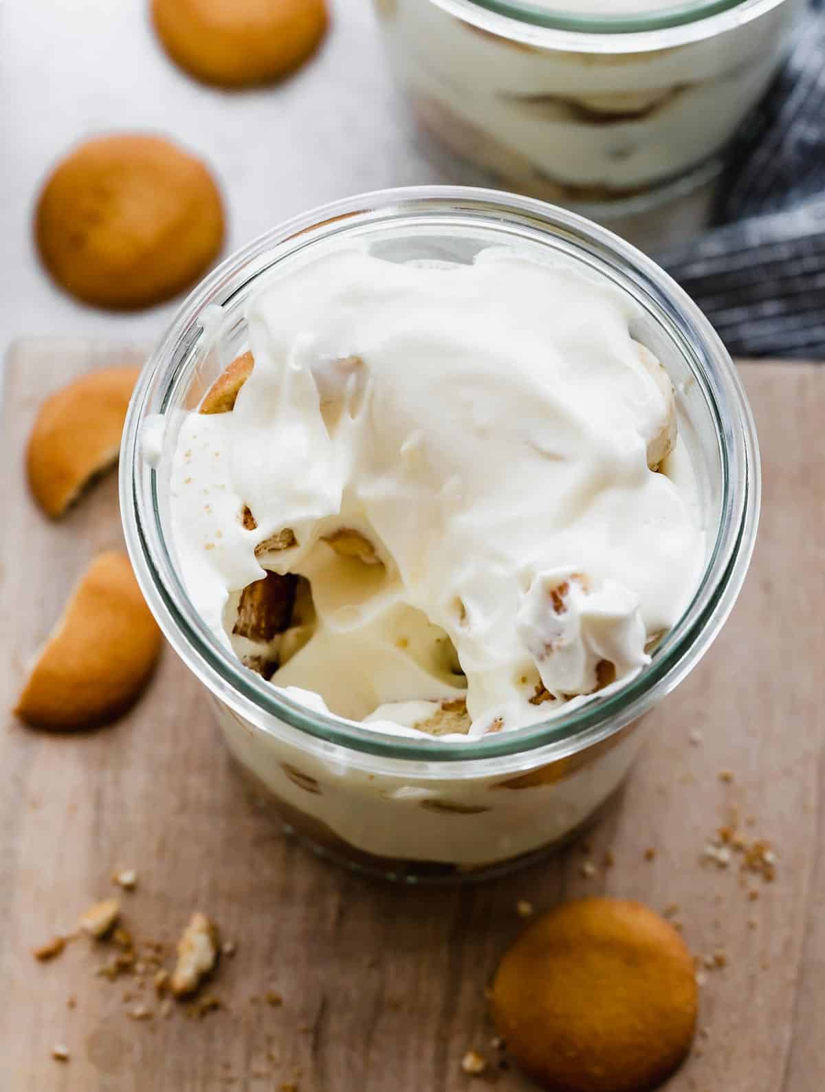 Overhead photo of Magnolia Bakery Banana Pudding in a glass jar on a wooden background.