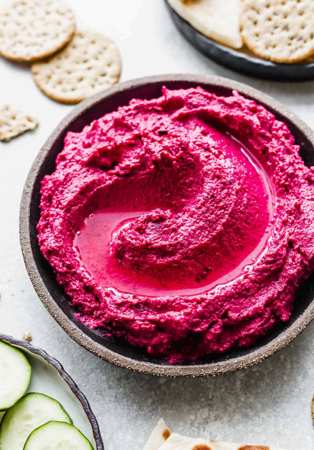 Beet Hummus on a black plate.