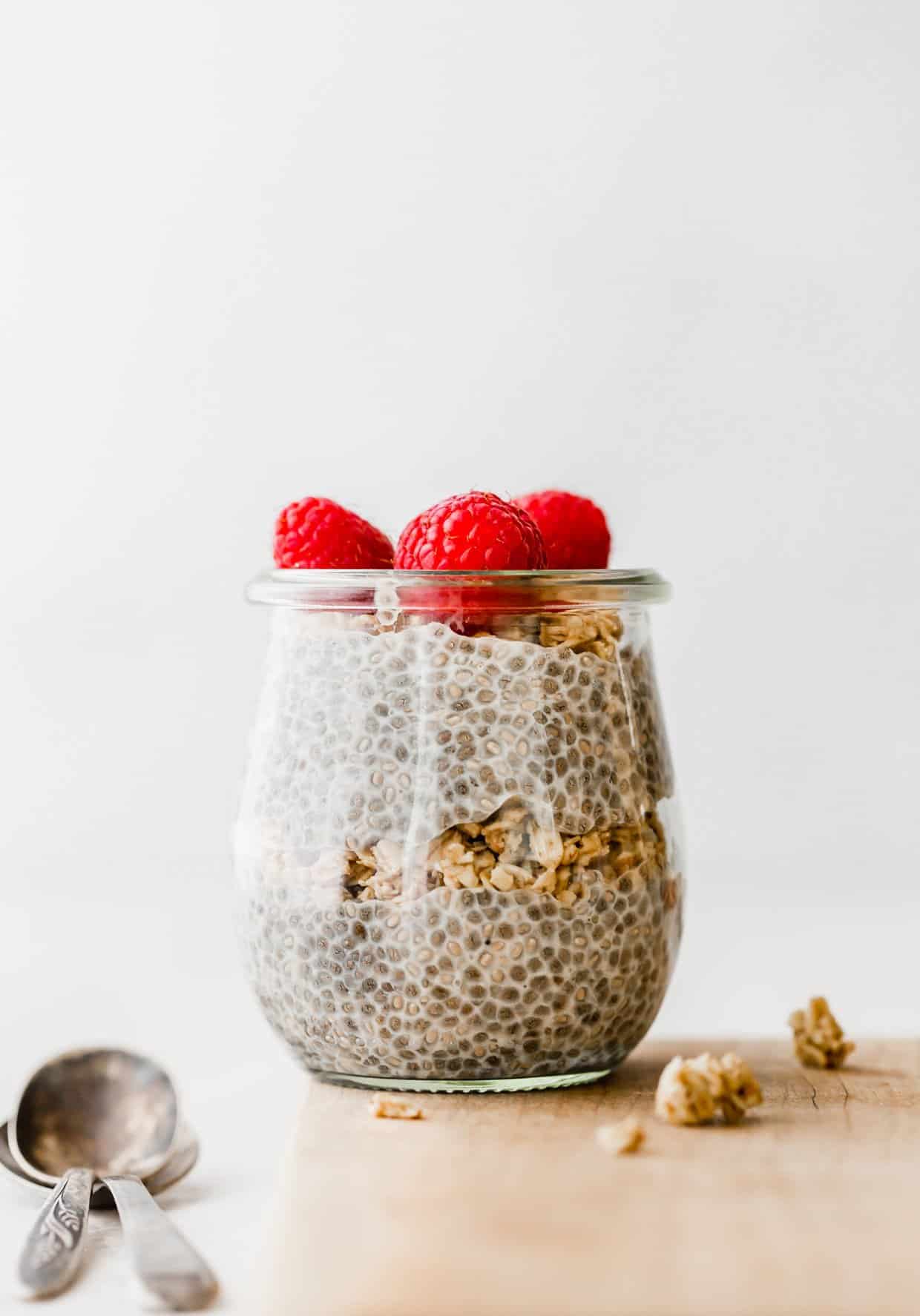 Chia pudding in a glass jar topped with fresh raspberries.