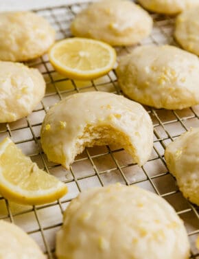A bite taken out of a Lemon Ricotta Cookie that's on a wire cooling rack.