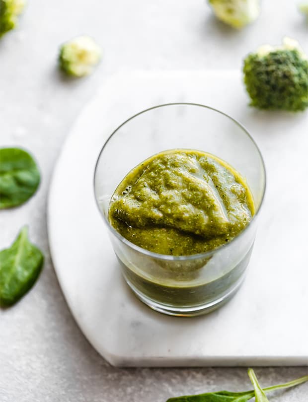 A healthy broccoli smoothie in a glass cup.