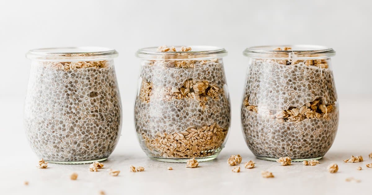 Three jars of chia pudding layered with granola. 