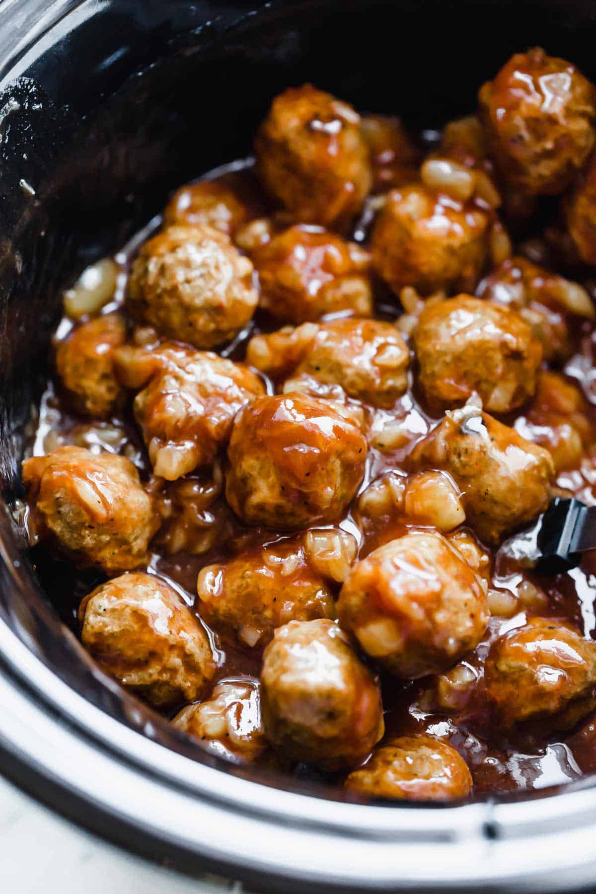 3 ingredient BBQ Pineapple Meatballs in a black slow cooker.