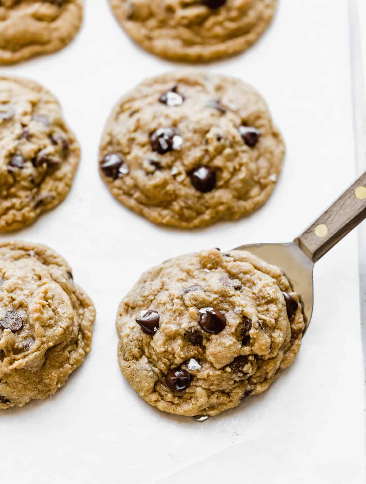 Brown Butter Chocolate Chip Cookies on a white parchment paper.