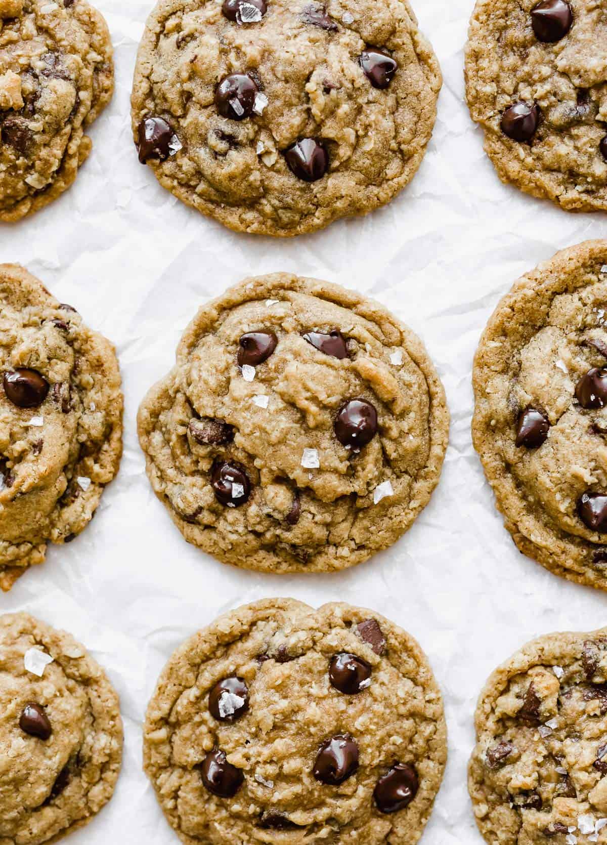 Brown Butter Chocolate Chip Cookies lined up side by side on a white background. 