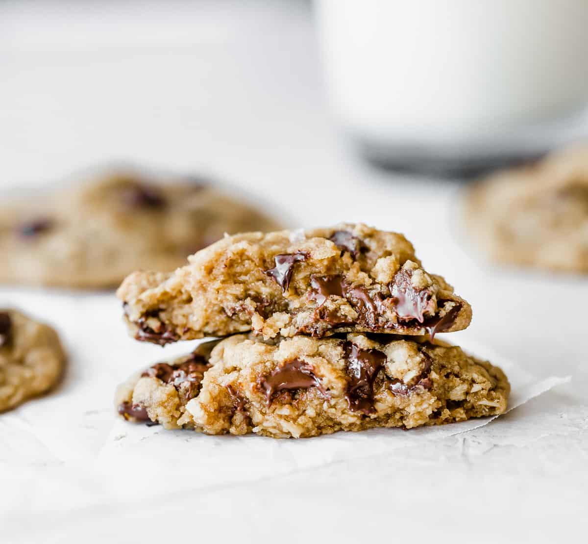 A brown butter chocolate chip cookie made with oat flour, split in half with each half on top of the other.