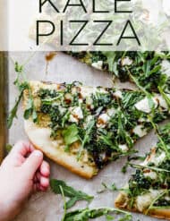 Delicious homemade kale pizza topped with fresh arugula, balsamic glaze and goat cheese.