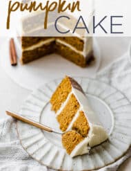 A slice of pumpkin cake on a plate, with the large cake in the background.