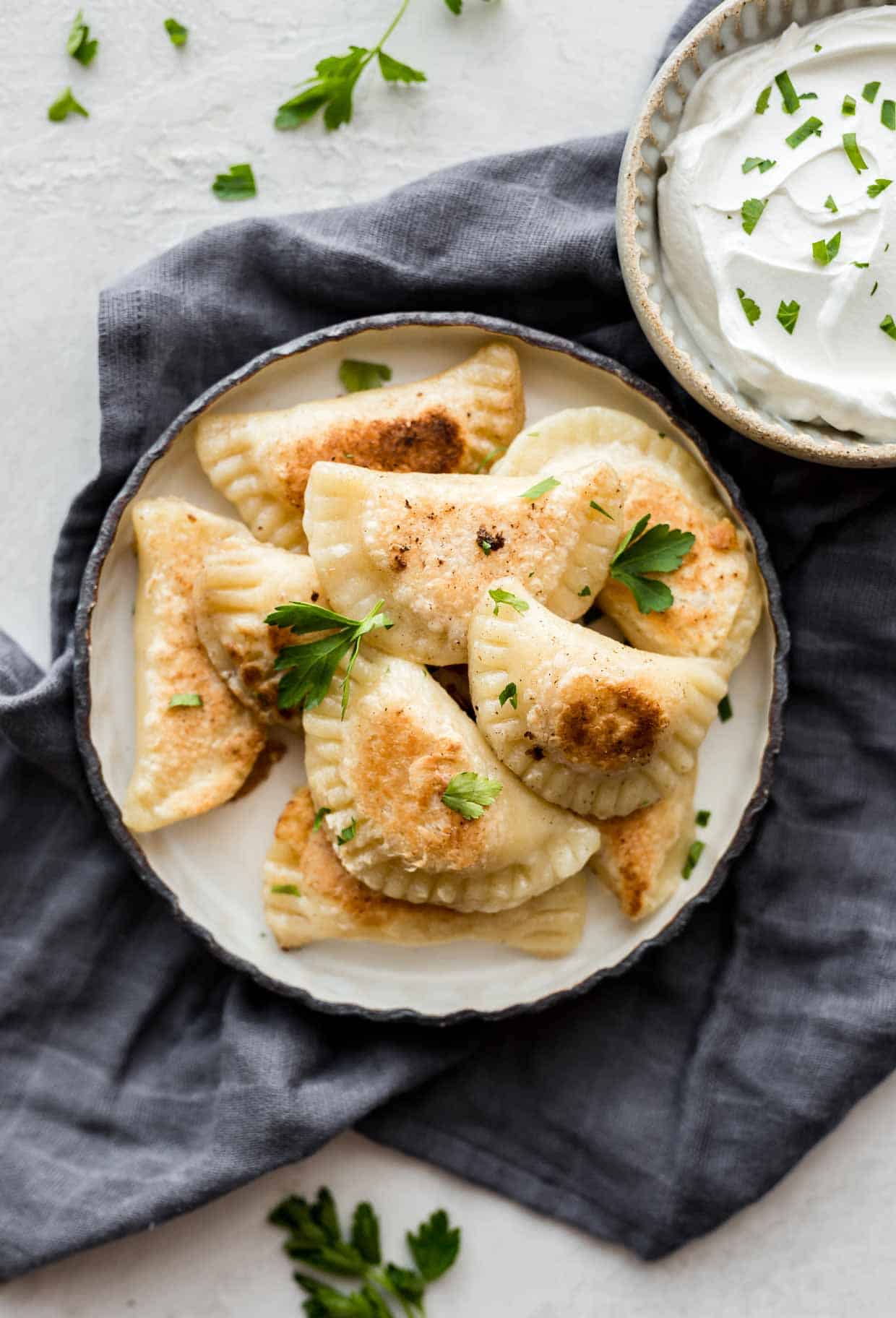 Homemade Pierogies on a plate with chives.