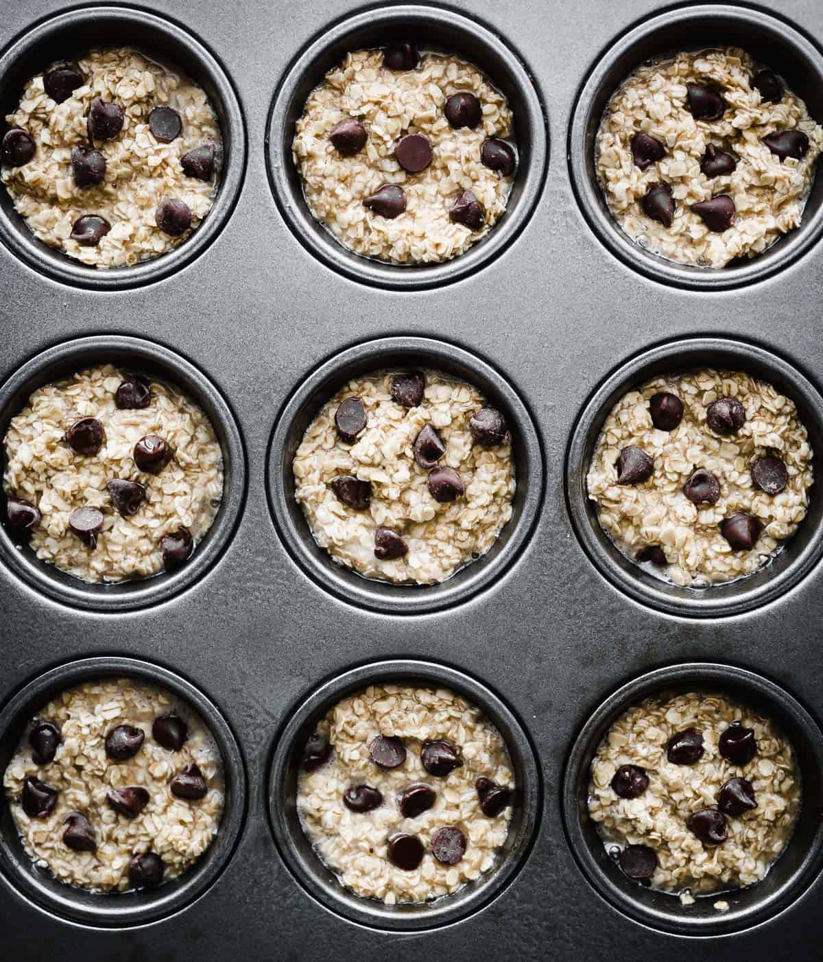 Baked Oatmeal Cups in a muffin tin topped with chocolate chips.