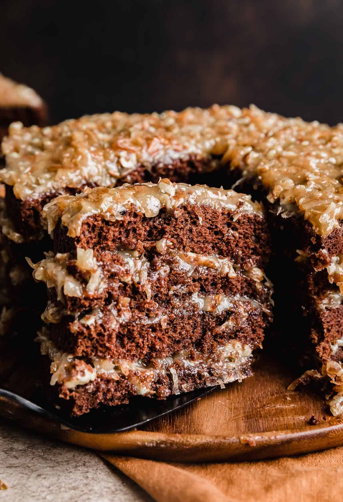 A slice of a four layer Traditional German Chocolate Cake balancing on a spatula. 
