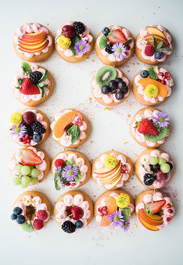 Donuts covered with fruits and flowers. 