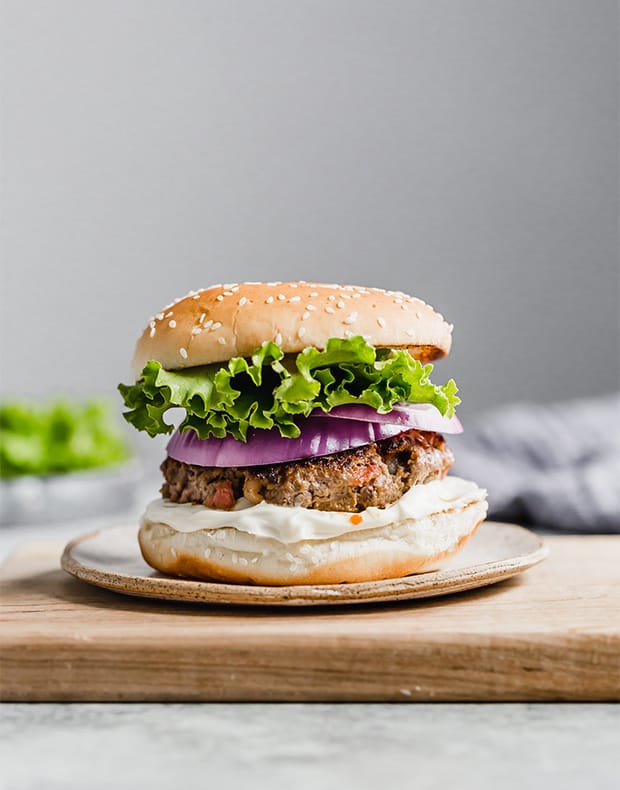 The best bacon burger on a hamburger bun, topped with lettuce and red onion.