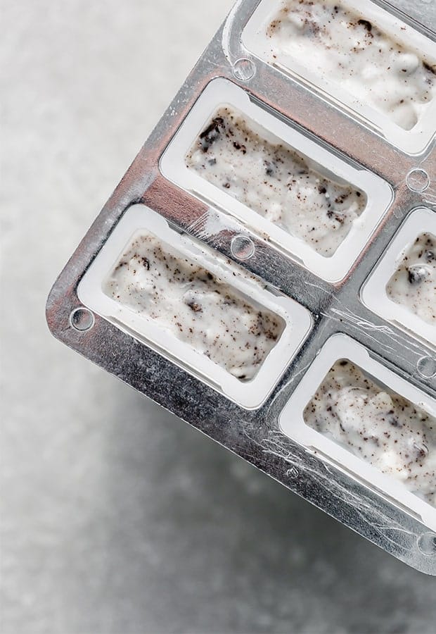 A popsicle mold full of cookies and cream mixture. 