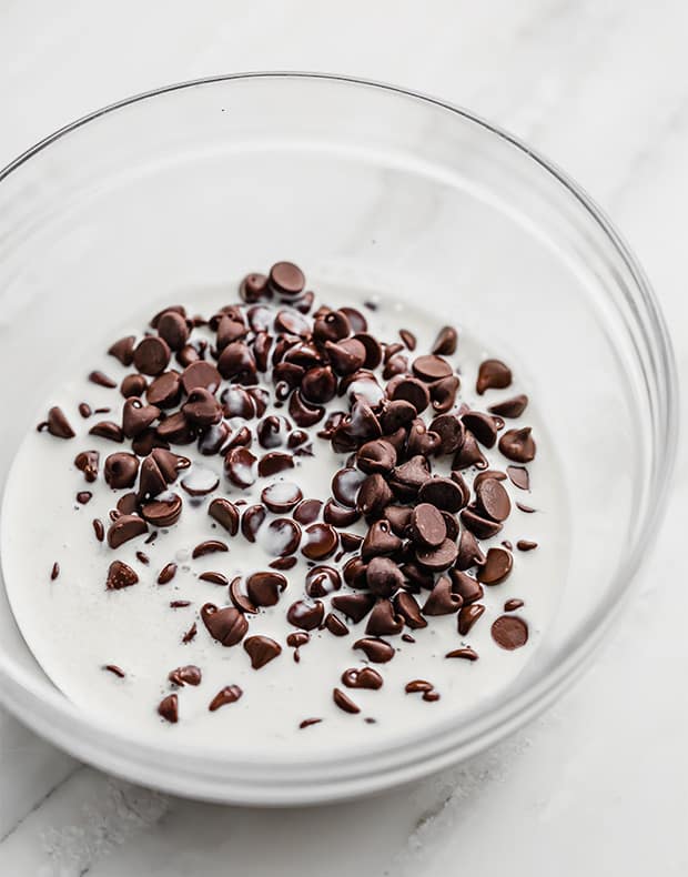 Chocolate chips and heavy cream in a bowl for making ganache.