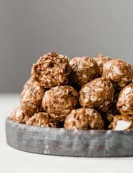 Almond Joy Protein Balls stacked on a round plate.
