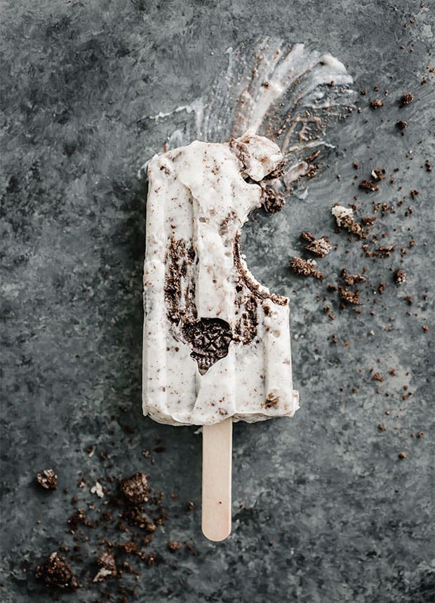 A cookies and Cream popsicle with a bite taken out of it. 