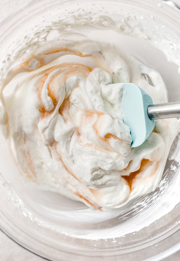 A bowl of freshly whipped cream mixed with peach juice.