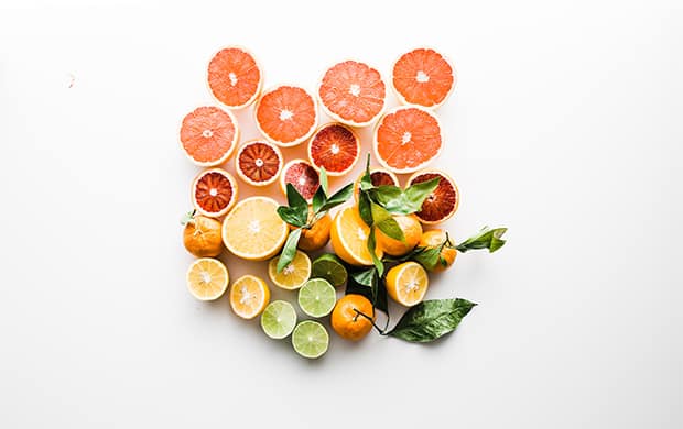 Photo by Brooke Lark, citrus fruits with surrounding greenery.