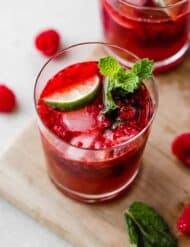 Overhead photo of a homemade raspberry mocktail topped with lime and fresh mint sprig.