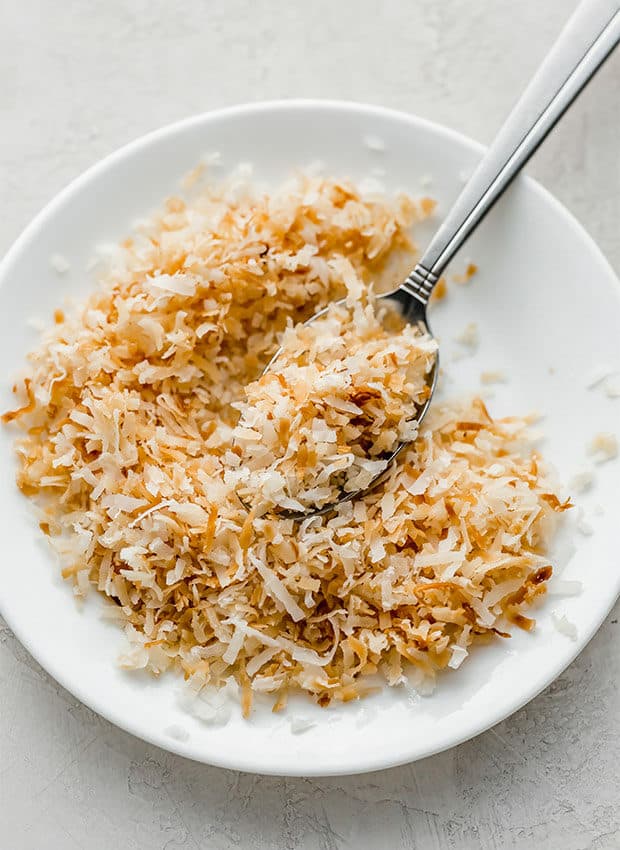 A white plate with toasted coconut made in the microwave.