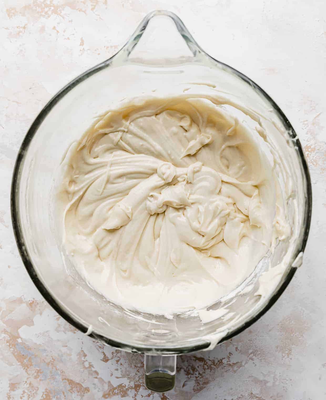 A vanilla cake batter for a smash cake recipe in a stand mixer bowl.