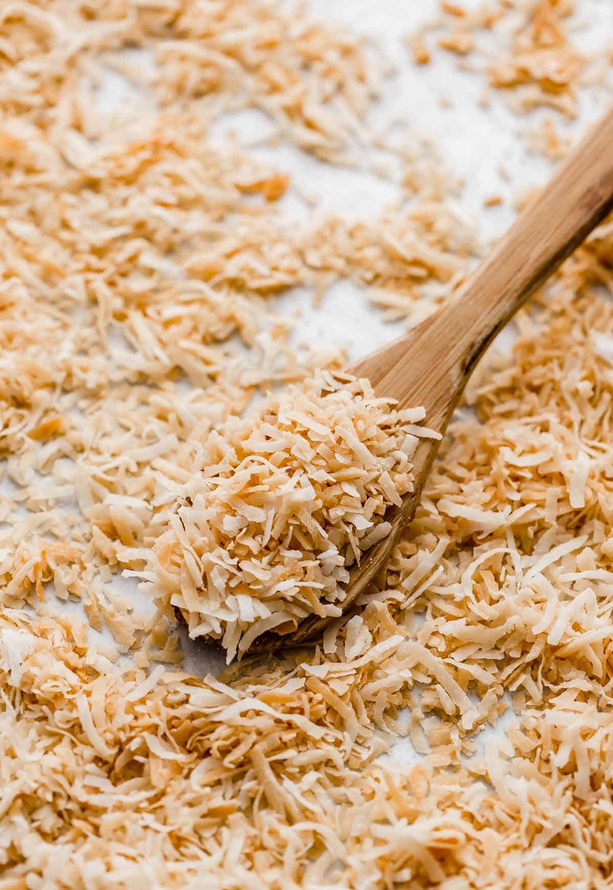 Toasted coconut on a wooden spoon.